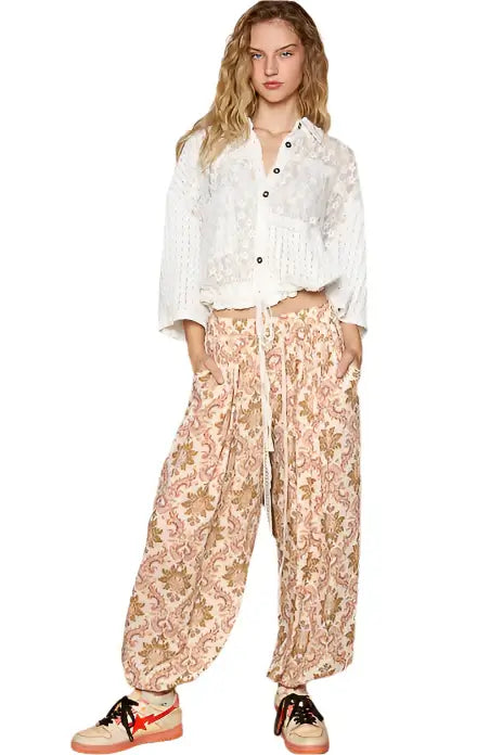 Model wearing a Vintage Lace Cropped Jacket Top in off white with floral patterned loose pants.