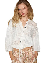 Vintage lace cropped jacket top in off white with button down and ruffled hem, styled with floral patterned bottoms.