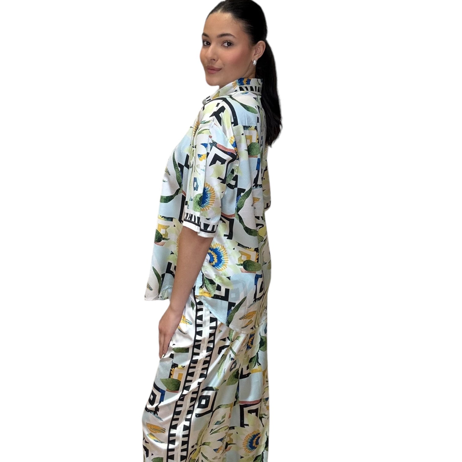 Model showcasing a satin sky button-down shirt and wide-leg pants set featuring a vibrant print.