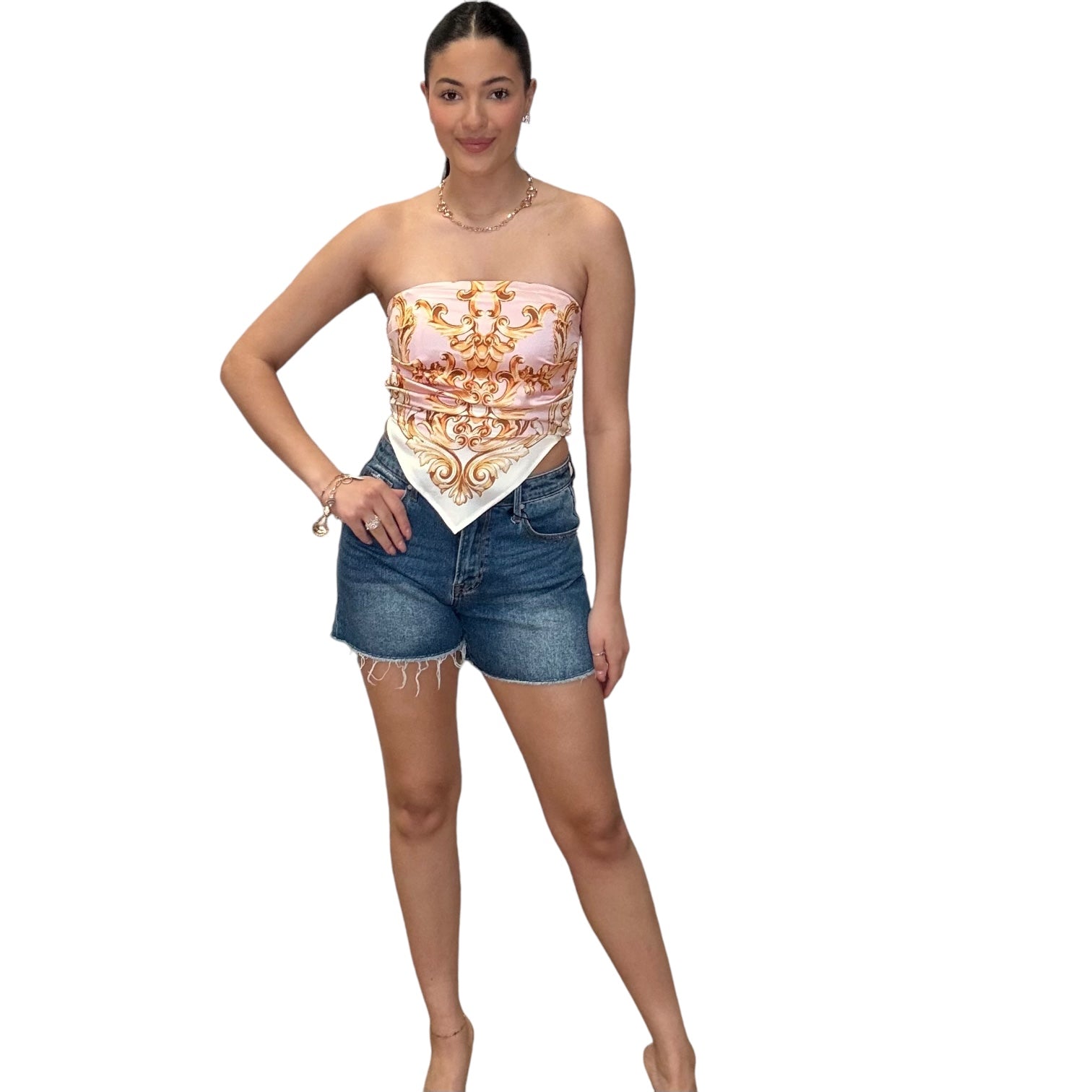 Model wearing a pink strapless satin scarf top paired with denim shorts, showcasing style and elegance.