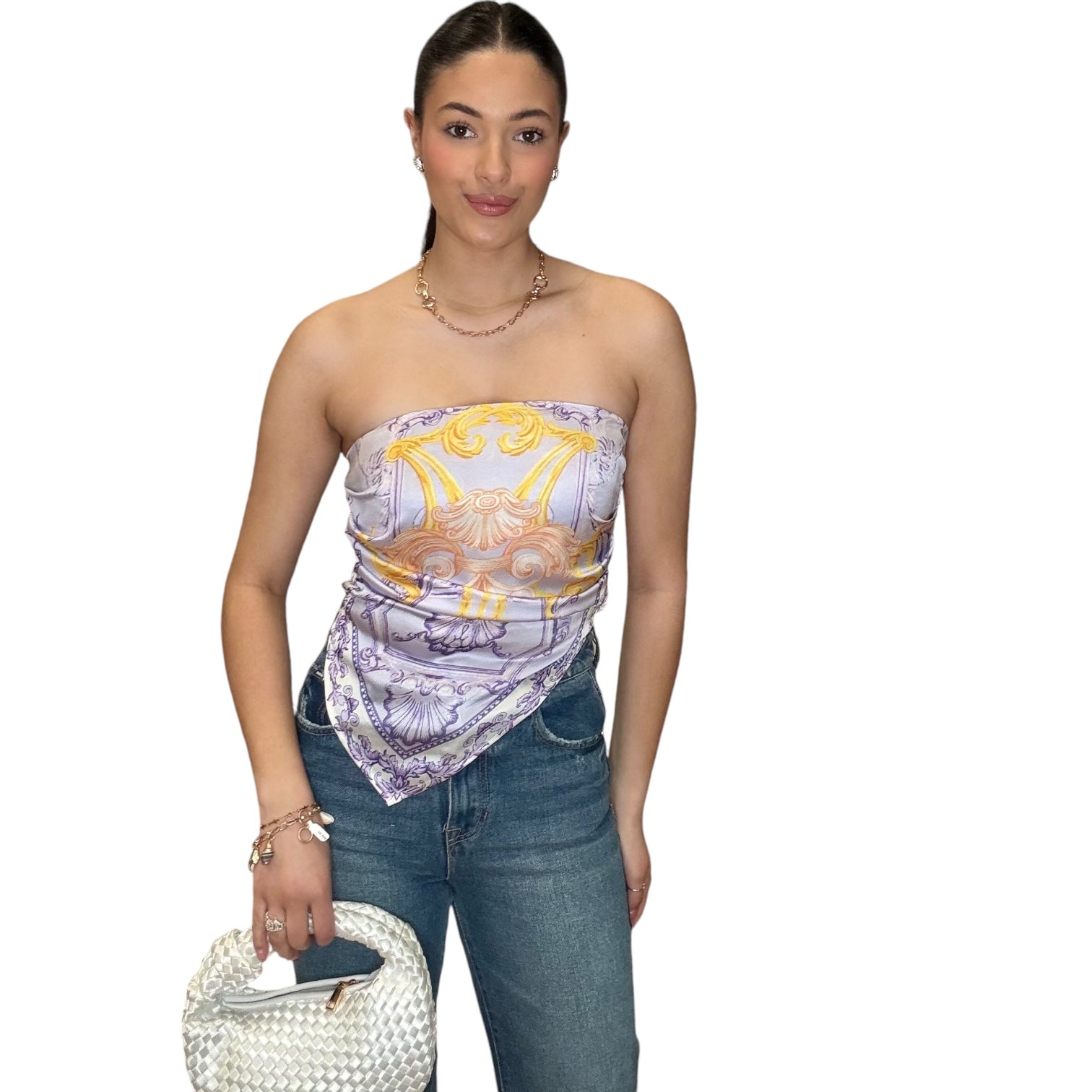 Model wearing a strapless lilac satin scarf top with an elegant neckline, paired with denim and a chic handbag.